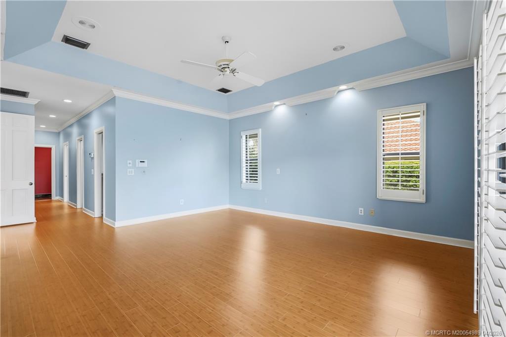 6273 Southeast Baltusrol Terrace Stuart, FL 34997 - Photo 34 of 68 an empty room with wooden floor and windows