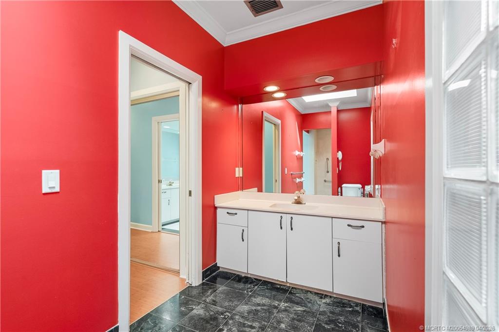 6273 Southeast Baltusrol Terrace Stuart, FL 34997 - Photo 43 of 68 a bathroom with a sink a mirror and a shower