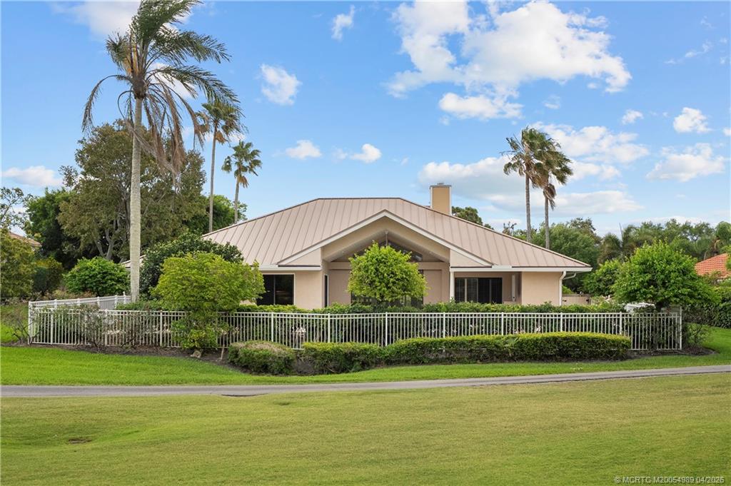 6273 Southeast Baltusrol Terrace Stuart, FL 34997 - Photo 53 of 68 a front view of a house with a garden