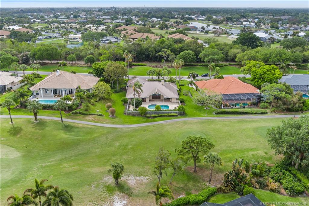 6273 Southeast Baltusrol Terrace Stuart, FL 34997 - Photo 66 of 68 an aerial view of residential houses with outdoor space and trees