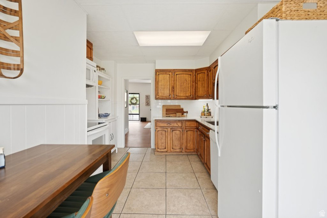 673 East 700 South Springville, UT 84663 - Photo 14 of 43 Kitchen featuring wood cabinetry, light-toned countertops, and tile flooring