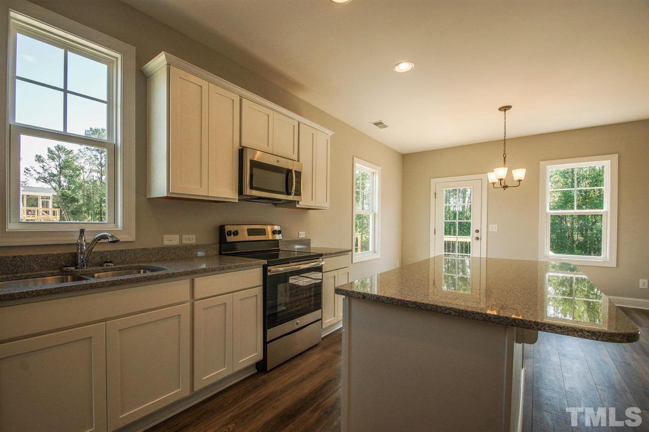 1128 Silver Farm Road Raleigh, NC 27603 - Photo 3 of 25 a kitchen with stainless steel appliances granite countertop a sink a stove cabinets counter space and a window