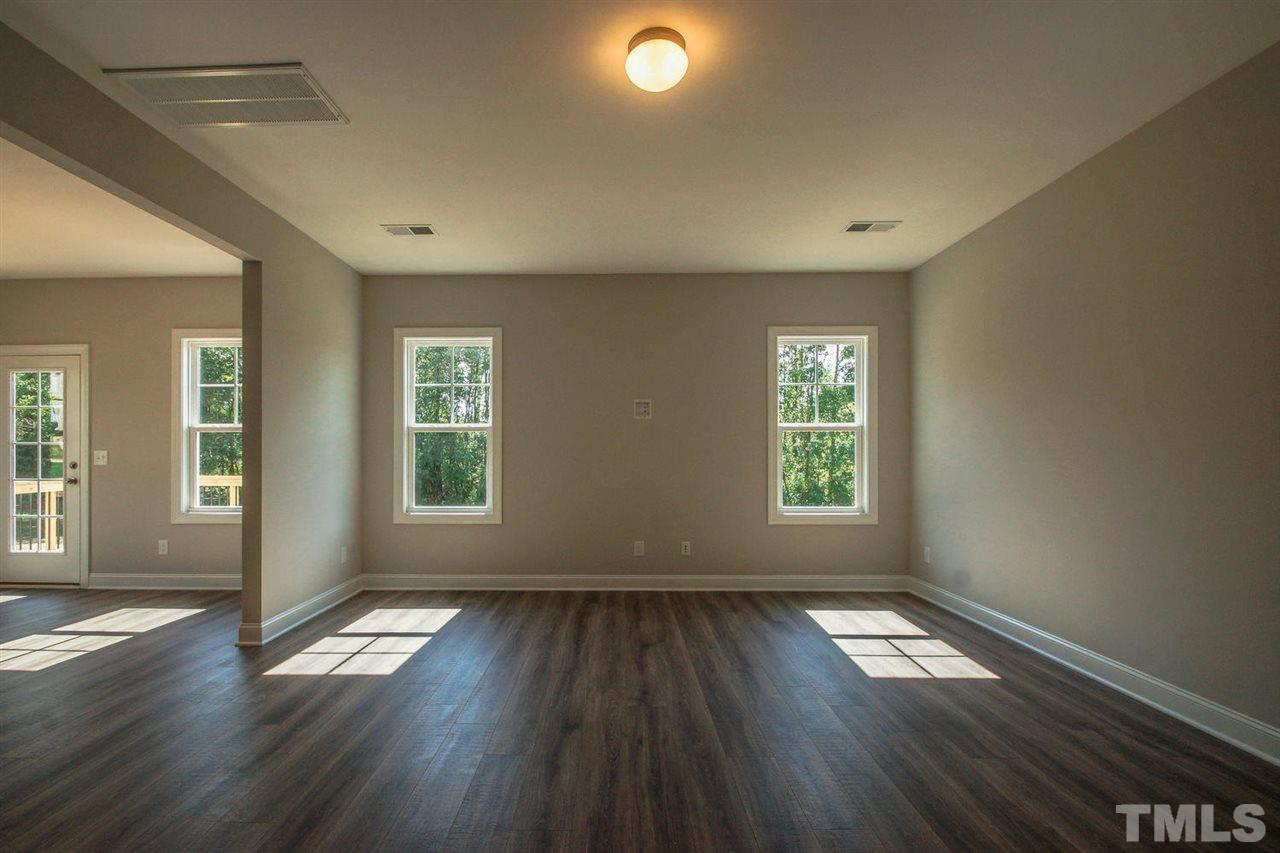 1128 Silver Farm Road Raleigh, NC 27603 - Photo 8 of 25 an empty room with wooden floor and windows
