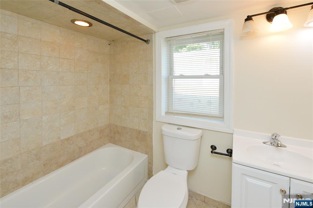 62 Broadway, Unit 1 Hackensack, NJ 07601 - Photo 18 of 25 a bathroom with a bathtub shower and toilet