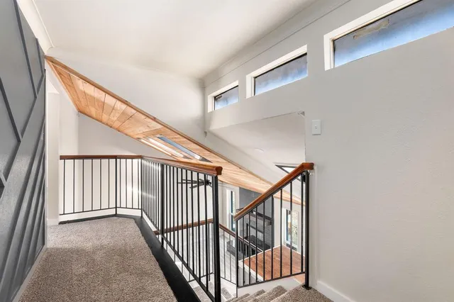 a view of staircase with railing and white walls