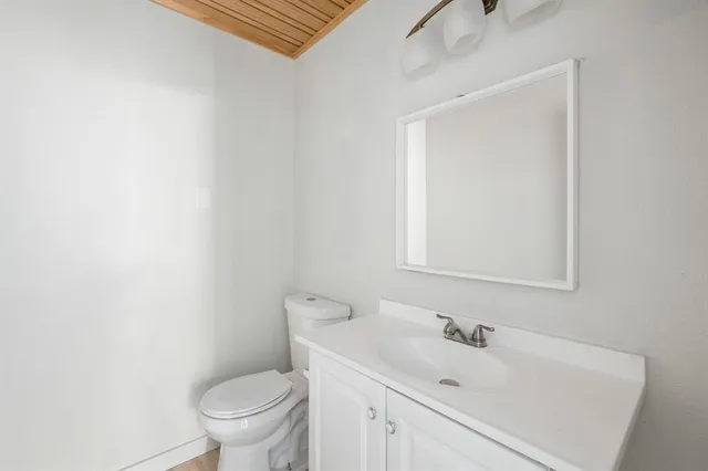 a bathroom with a sink toilet and mirror