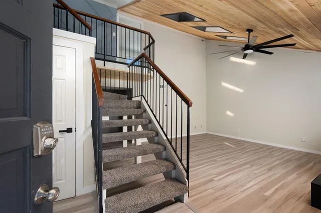 a view of staircase with wooden floor and fan