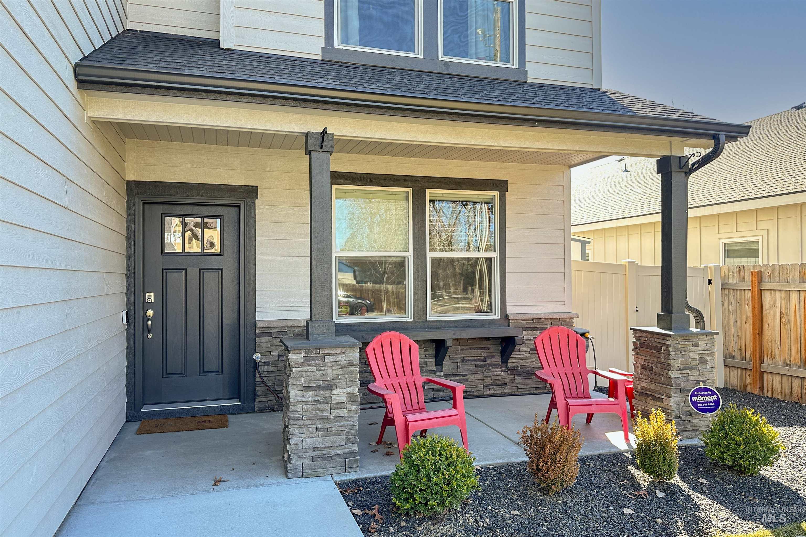 9687 West Arnold Road Boise, ID 83714 - Photo 3 of 37 Covered front porch featuring stacked stone accents, decorative pillars, and a paneled entry door with an inset window