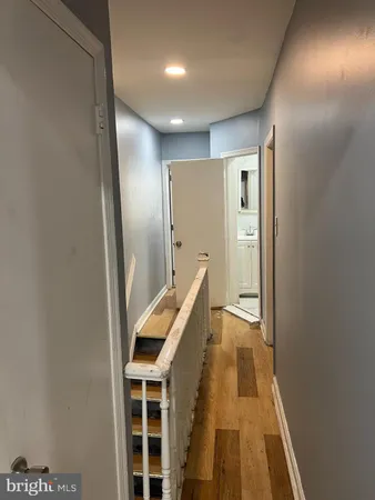a view of a hallway with wooden floor and staircase