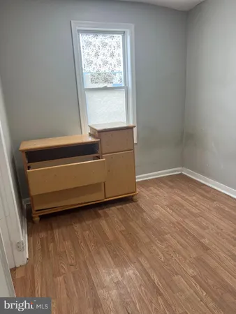 a room with a wooden floor and a window