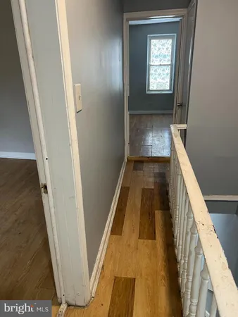 a view of a hallway with wooden floor and stairs