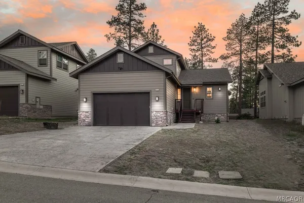 a front view of a house with yard and trees