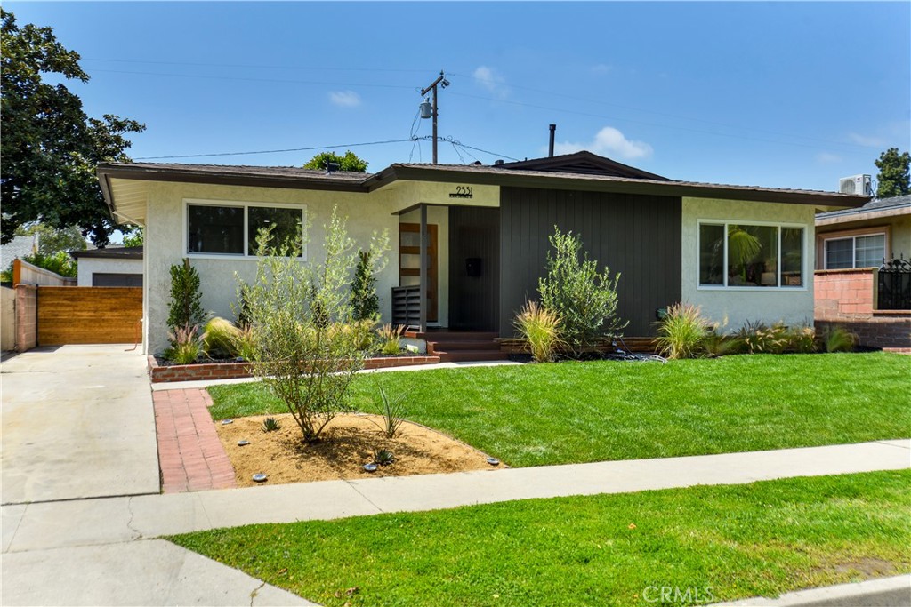 a front view of a house with a garden and plants