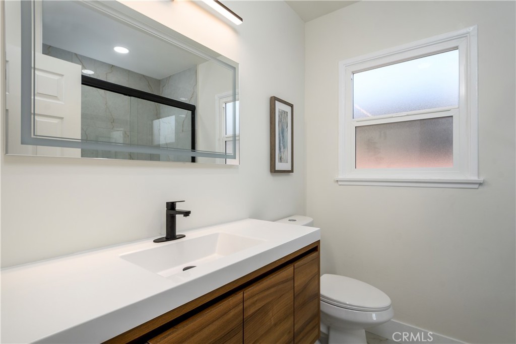 2531 North Studebaker Road Long Beach, CA 90815 - Photo 15 of 34 a bathroom with a sink a toilet and mirror