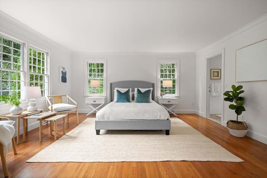 201 Smoke Valley Road Osterville, MA 02655 - Photo 22 of 48 a spacious bedroom with a large bed and a potted plant