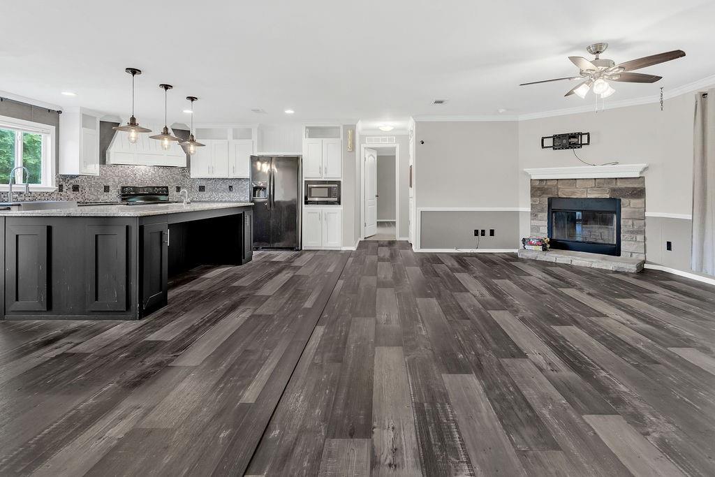 636 Roberson Road Hallsville, TX 75650 - Photo 14 of 36 a large kitchen with granite countertop a stove top oven a sink dishwasher and a fireplace with wooden floor