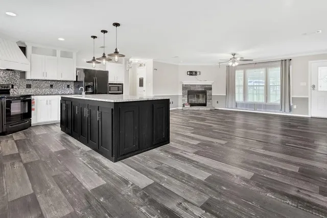 a large kitchen with stainless steel appliances granite countertop a stove and cabinets