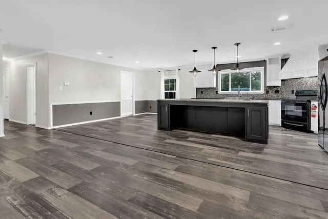 a large kitchen with kitchen island a sink stainless steel appliances and cabinets