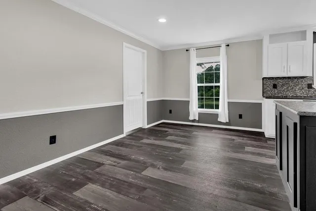 a view of empty room with wooden floor and fireplace