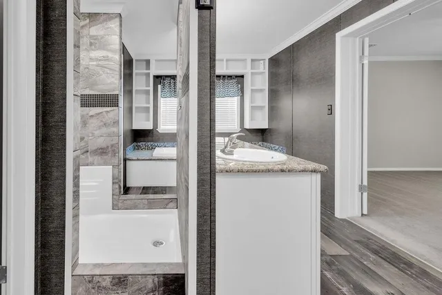 a kitchen with granite countertop a sink and a white wooden cabinets