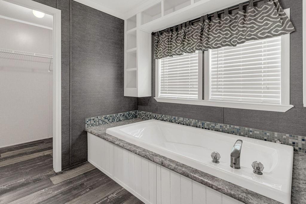 636 Roberson Road Hallsville, TX 75650 - Photo 35 of 36 a bath tub sitting in a bathroom next to a window