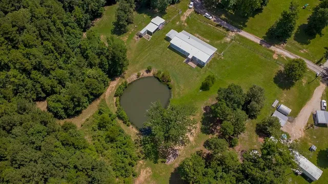 an aerial view of a house with swimming pool and green space