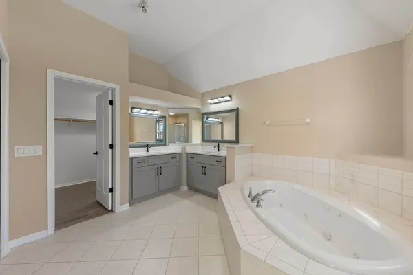 a large en suite bathroom with a tub sink and mirror