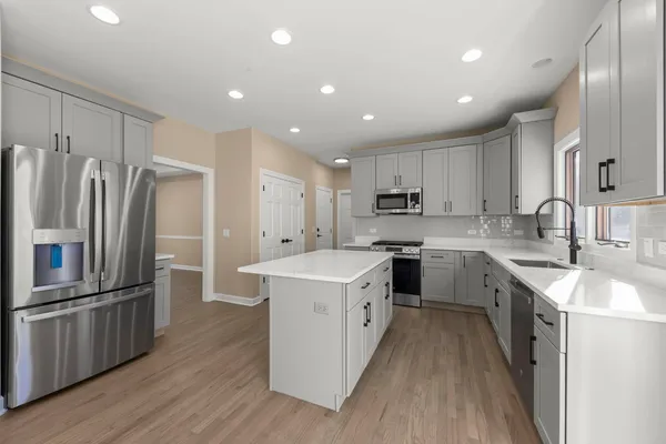a kitchen with stainless steel appliances a refrigerator sink and cabinets
