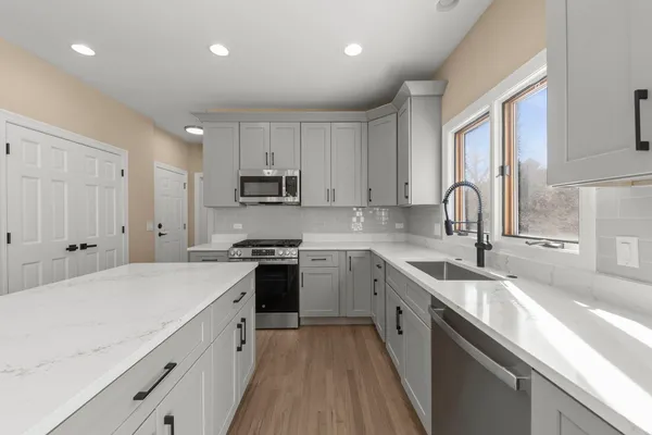 a kitchen with kitchen island granite countertop a sink stainless steel appliances and window