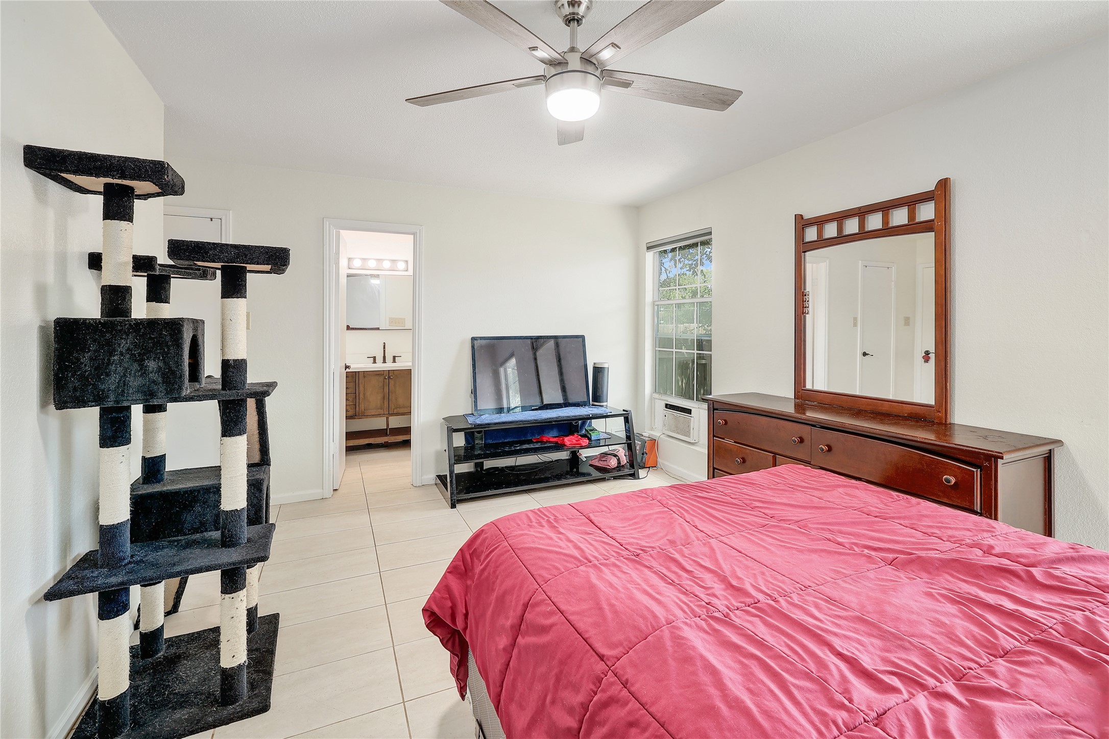 9906 Parliament House Road Austin, TX 78729 - Photo 22 of 33 Tiled floors and a window to the yard complete this peaceful bedroom.
