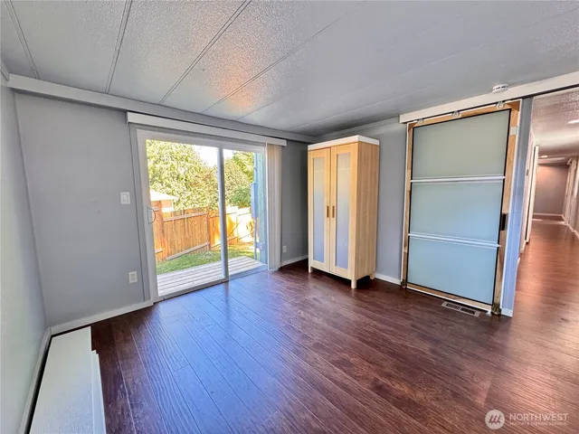 an empty room with wooden floor and sliding door