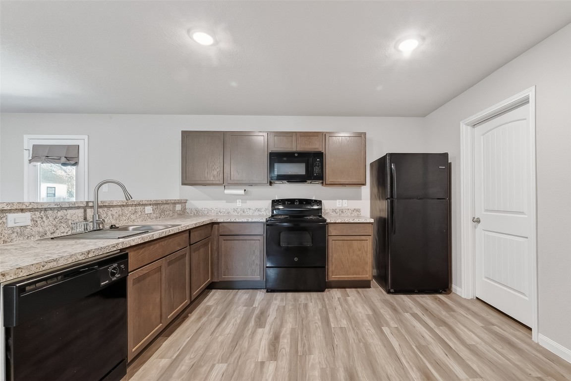 2516 Boss Street La Marque, TX 77568 - Photo 18 of 46 a kitchen with a sink a refrigerator and a stove top oven