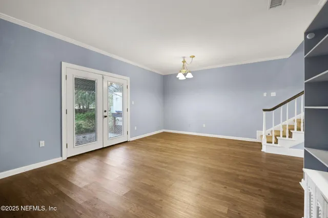 a view of a hallway with wooden floor and staircase