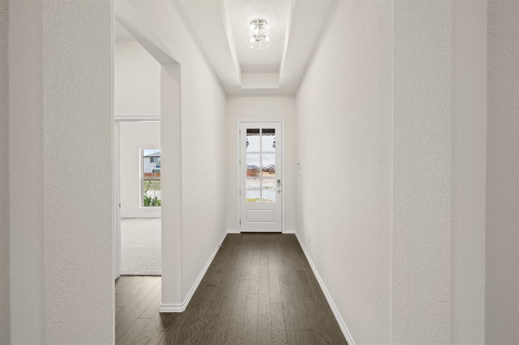 10809 Rothland Street Crowley, TX 76036 - Photo 15 of 30 a view of a hallway with wooden floor and a bathroom