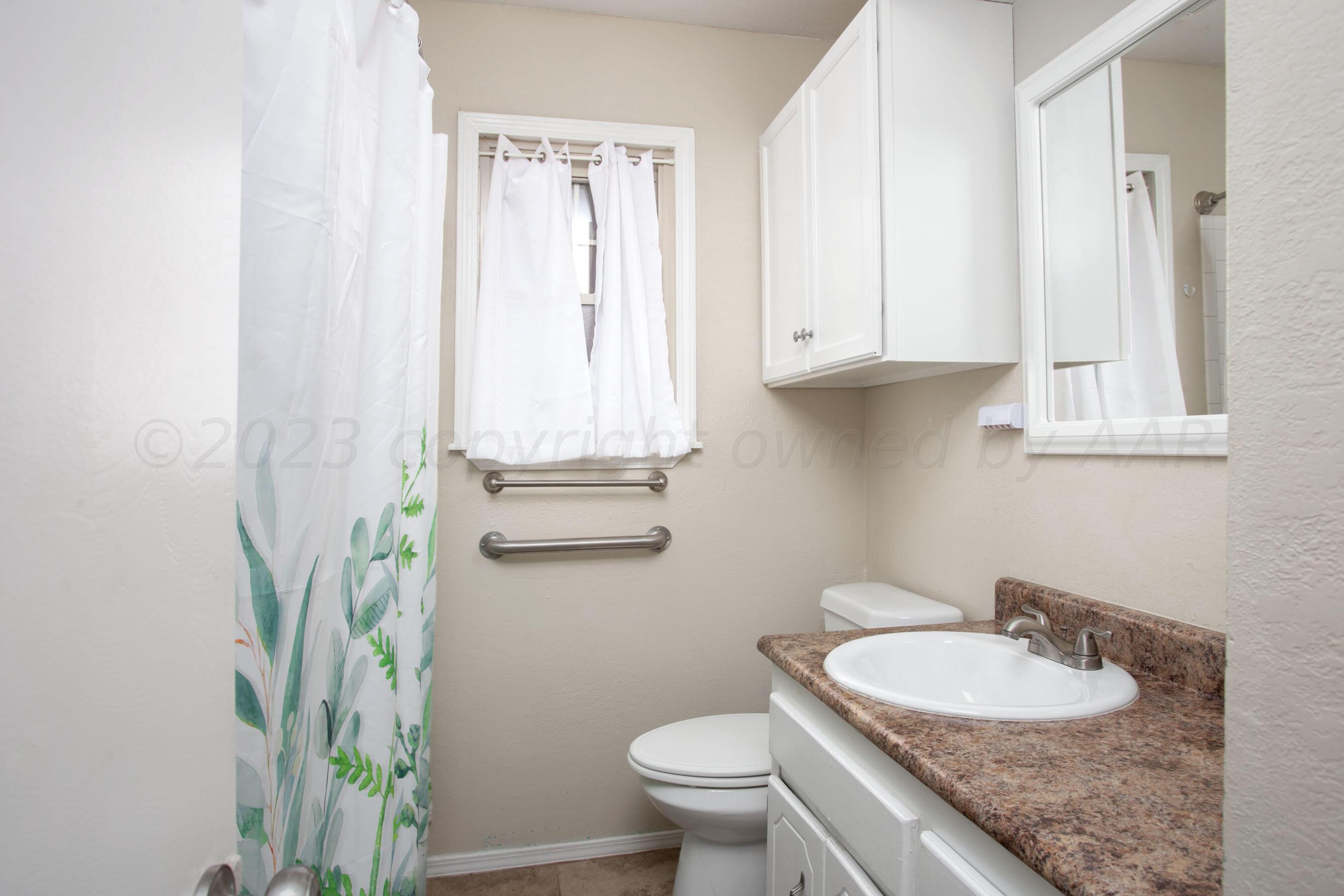 2905 Salem Drive Amarillo, TX 79110 - Photo 20 of 29 a bathroom with a granite countertop sink a toilet and a mirror