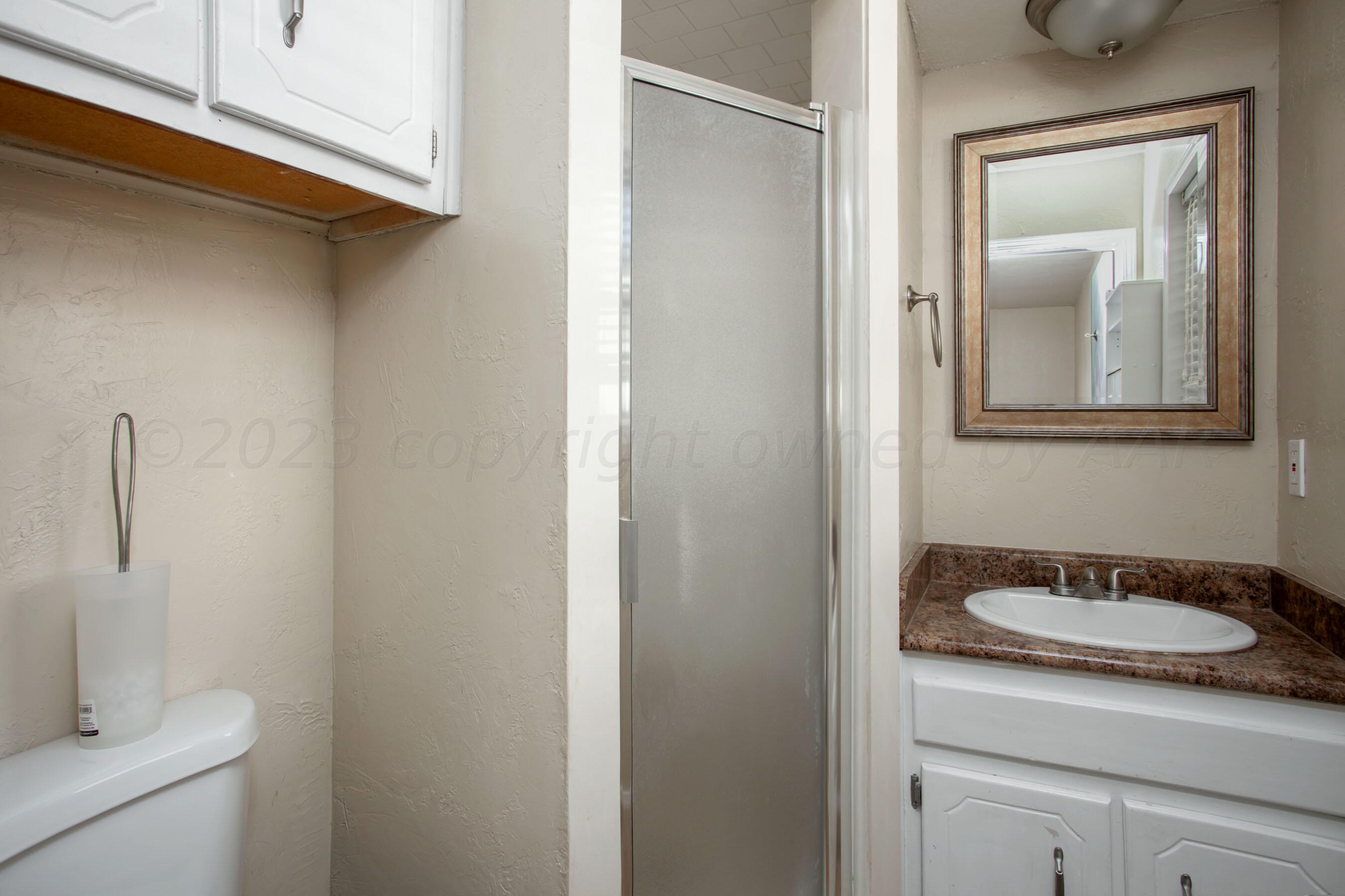 2905 Salem Drive Amarillo, TX 79110 - Photo 22 of 29 a bathroom with a sink a toilet and mirror