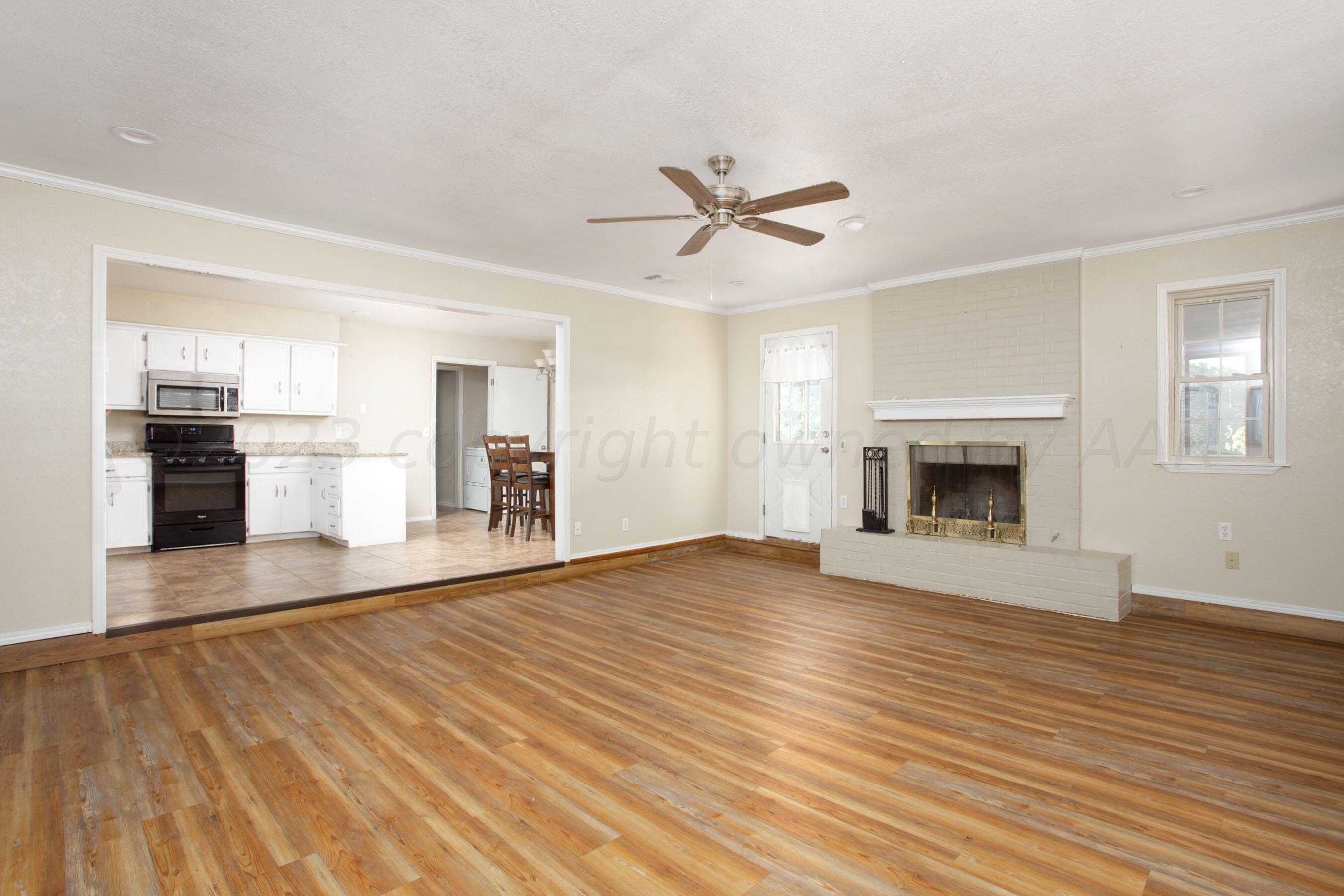 2905 Salem Drive Amarillo, TX 79110 - Photo 6 of 29 a view of empty room with wooden floor and fireplace