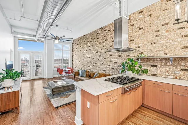 a kitchen with stainless steel appliances granite countertop a refrigerator a stove and a sink with wooden floor