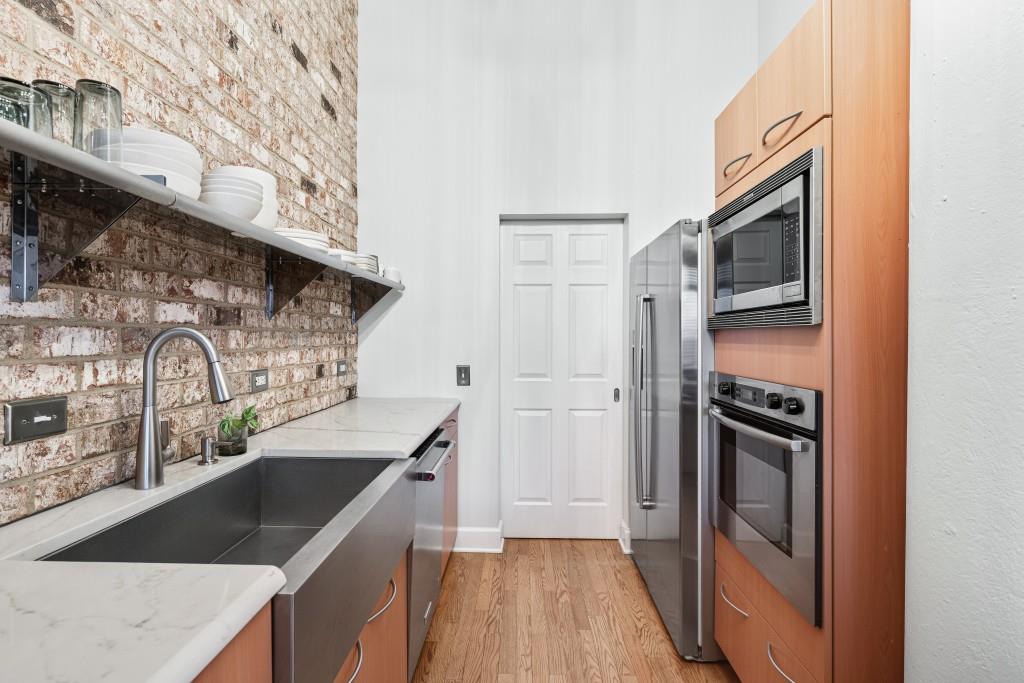 3820 Roswell Road Northeast, Unit 705 Atlanta, GA 30342 - Photo 18 of 62 a kitchen with stainless steel appliances granite countertop a refrigerator a stove and a sink with wooden floor