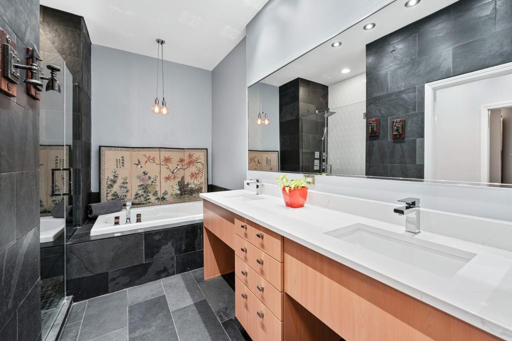3820 Roswell Road Northeast, Unit 705 Atlanta, GA 30342 - Photo 4 of 62 a bathroom with a double vanity sink a mirror and a bathtub