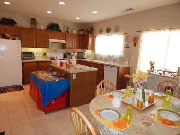 a kitchen with stainless steel appliances granite countertop a stove a sink dishwasher and a refrigerator with wooden floor