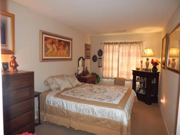 a bedroom with a bed a dresser and a window