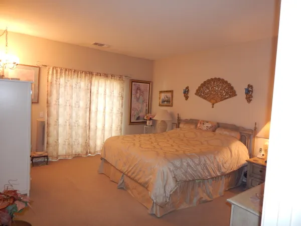 a bed sitting in a spacious bedroom next to a window