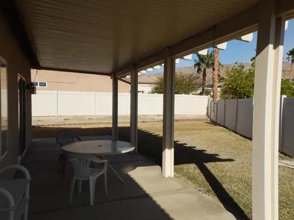 a view of a porch with chairs and backyard