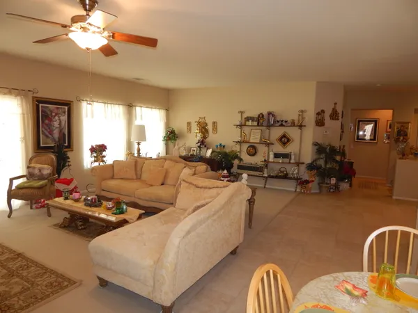 a living room with furniture kitchen view and a window