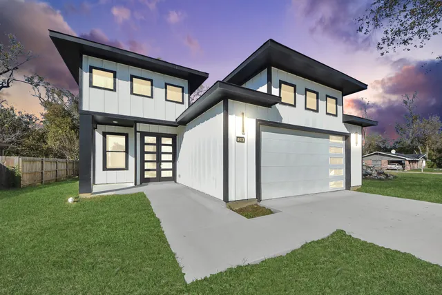 a front view of a house with a yard and garage