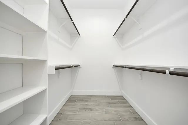 a view of walk in closet with empty racks