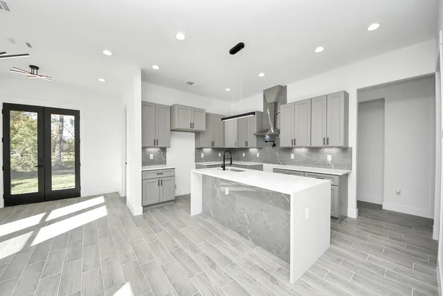 a large kitchen with stainless steel appliances granite countertop a large stove a sink dishwasher and a refrigerator with wooden floor