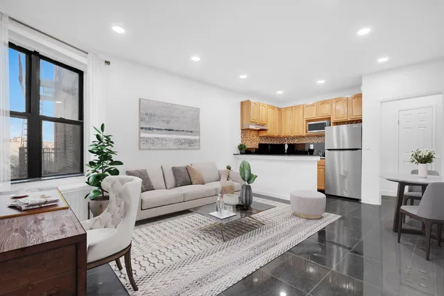 a living room with furniture and kitchen view