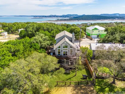 a view of house with outdoor space and a lake view in back